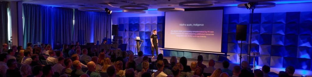 Michał Weiser presenting on stage to a conference audience